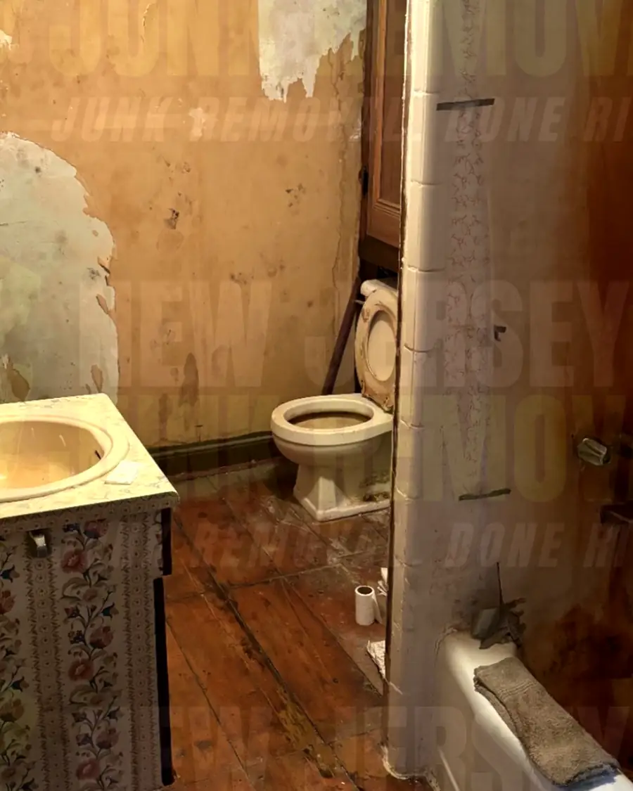 Before: an old bathroom with a vanity, toilet and a tub with its surround still in place