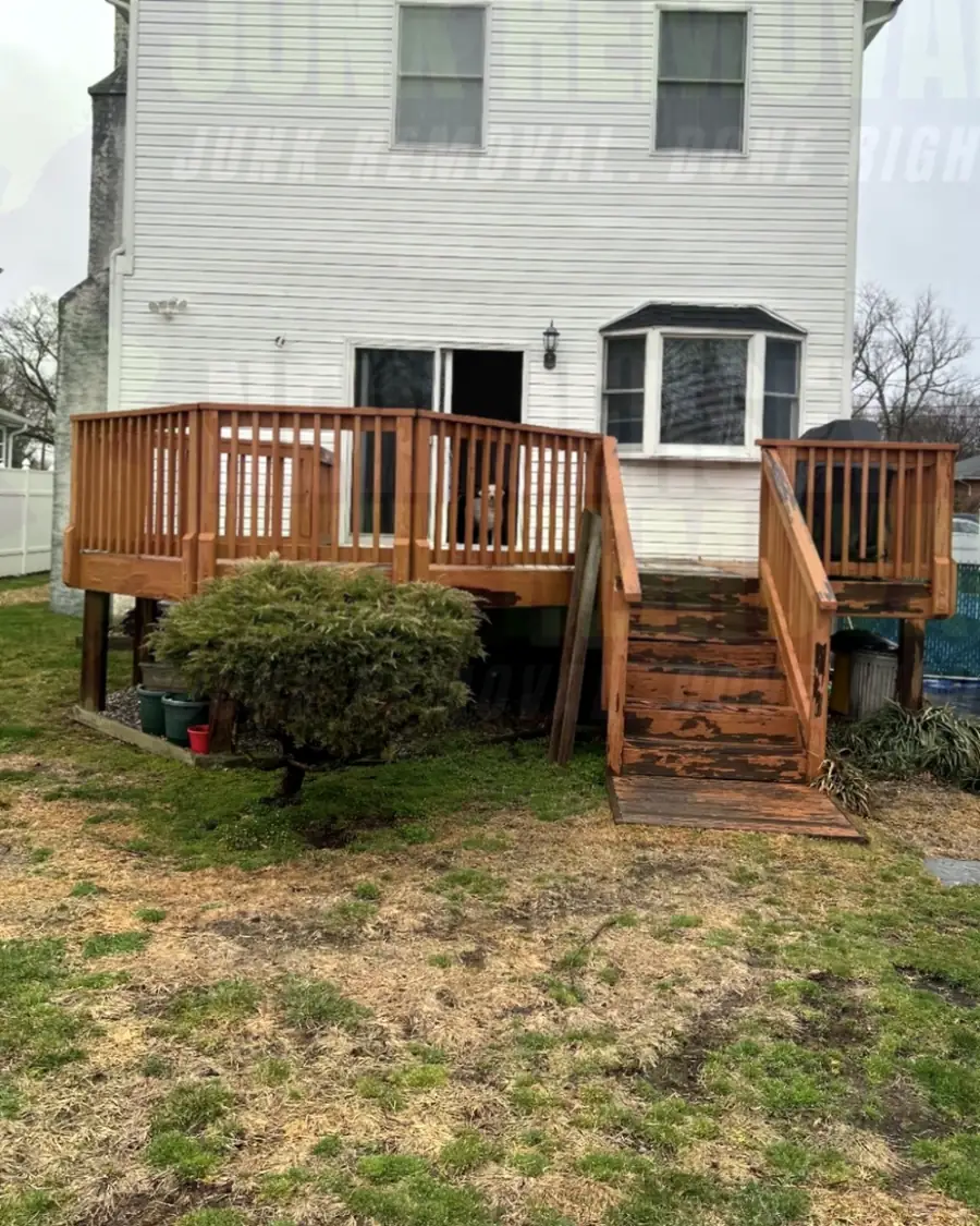 Before: the back of a house with a wooden deck and stairs