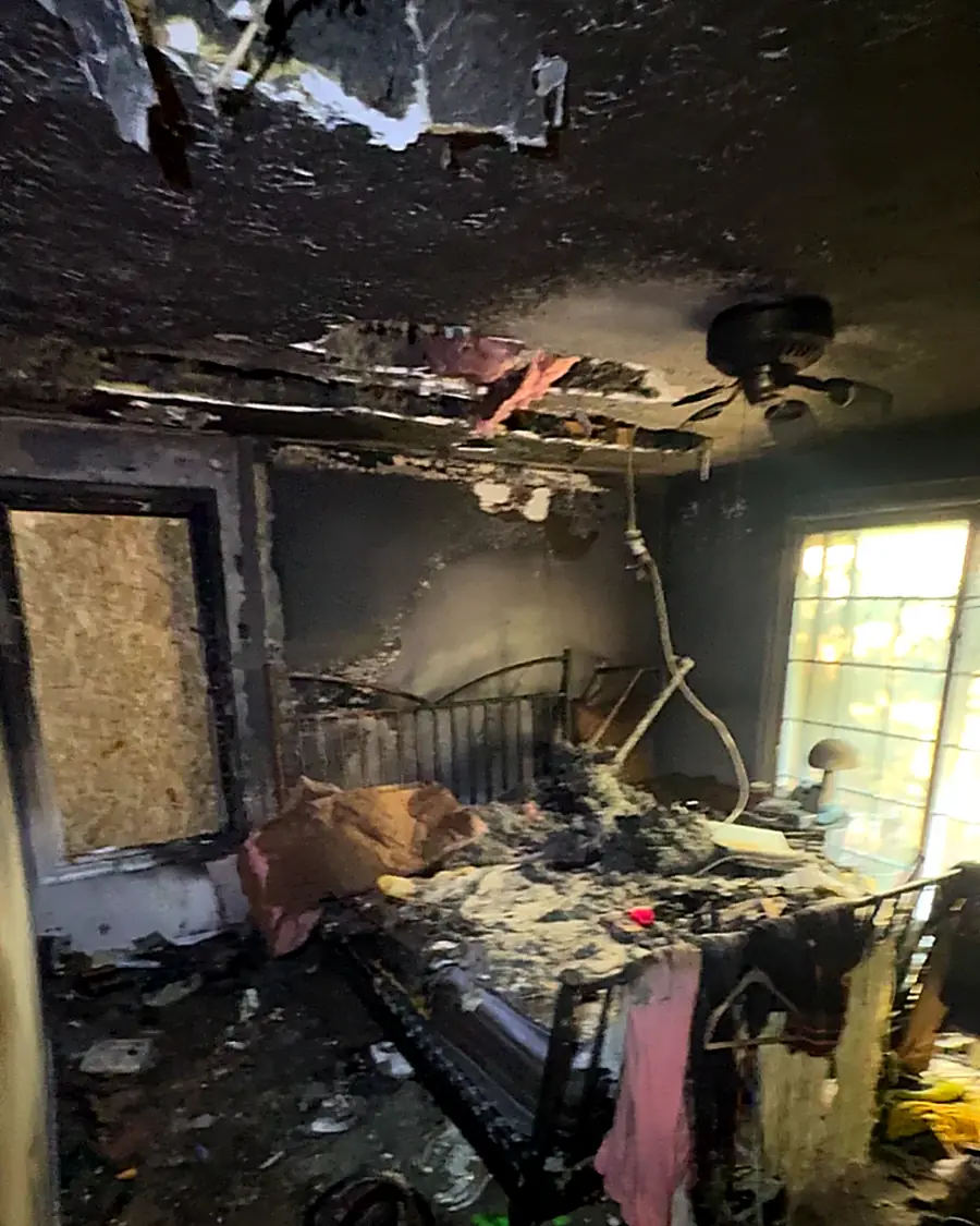 Before: a fire-damaged bedroom with a burned bed, charred ceiling and debris on the floor