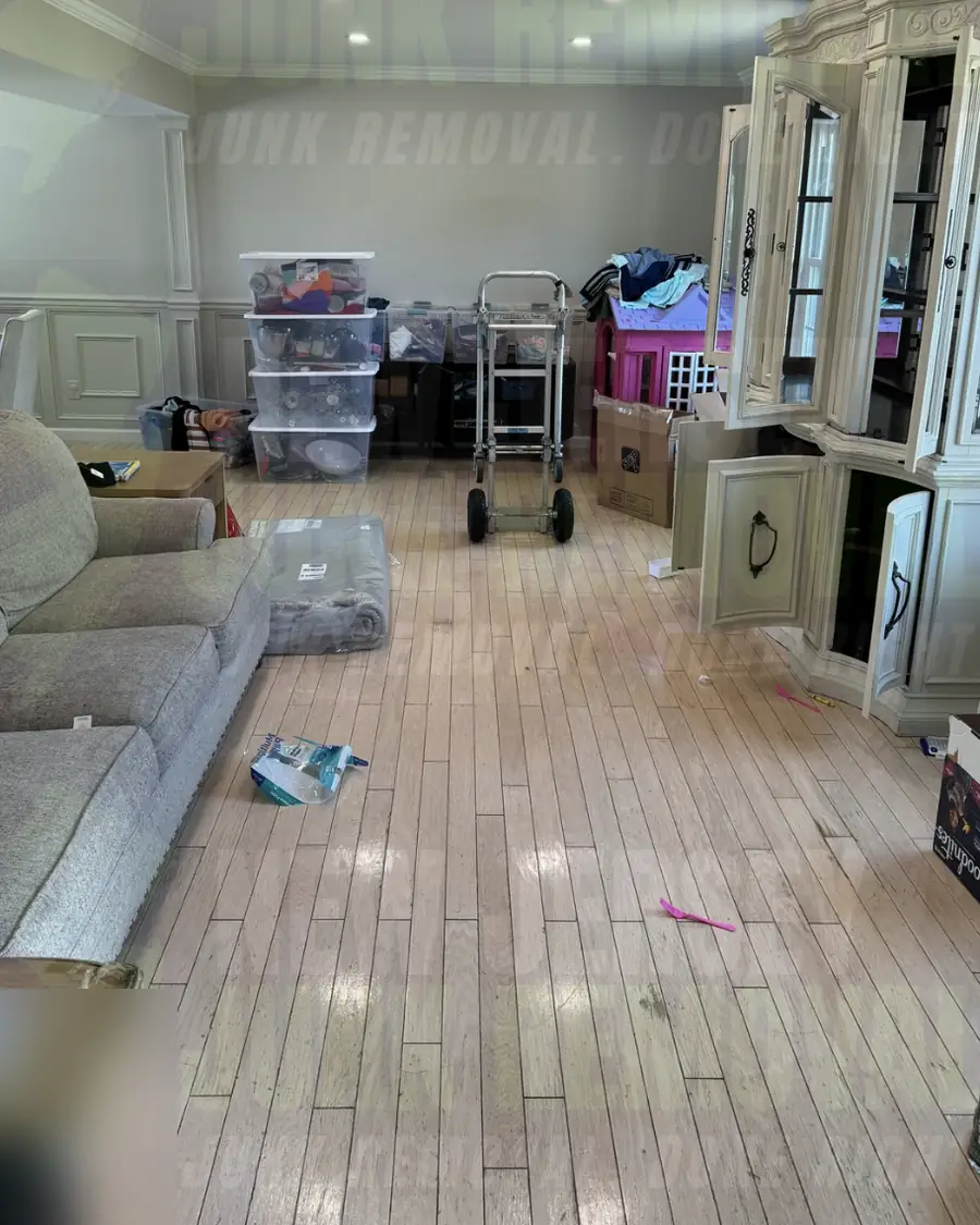 Before: a living area with a large china hutch, sofa and boxes