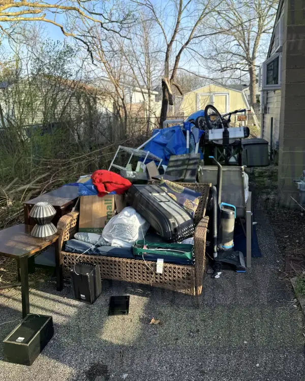Before: a pile of wicker patio furniture, side tables, luggage and bags beside a house