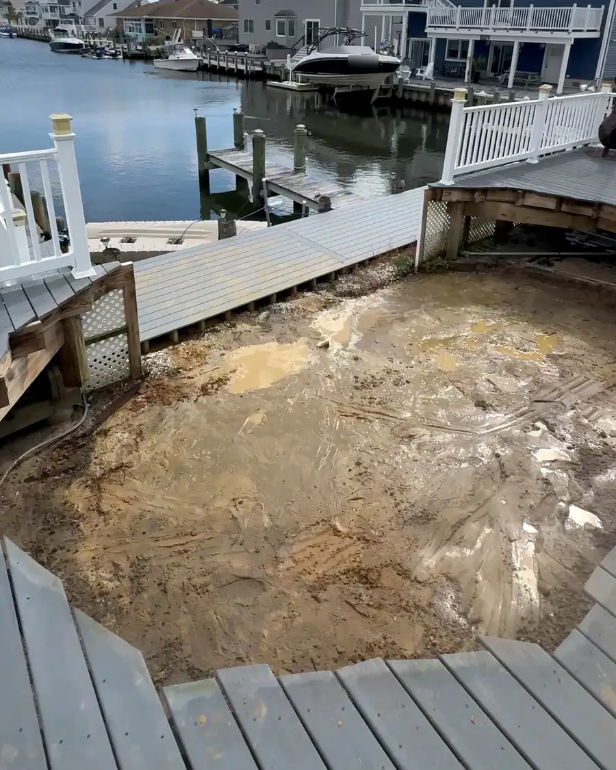 After: the same spot with the pool gone, down to bare ground inside the deck