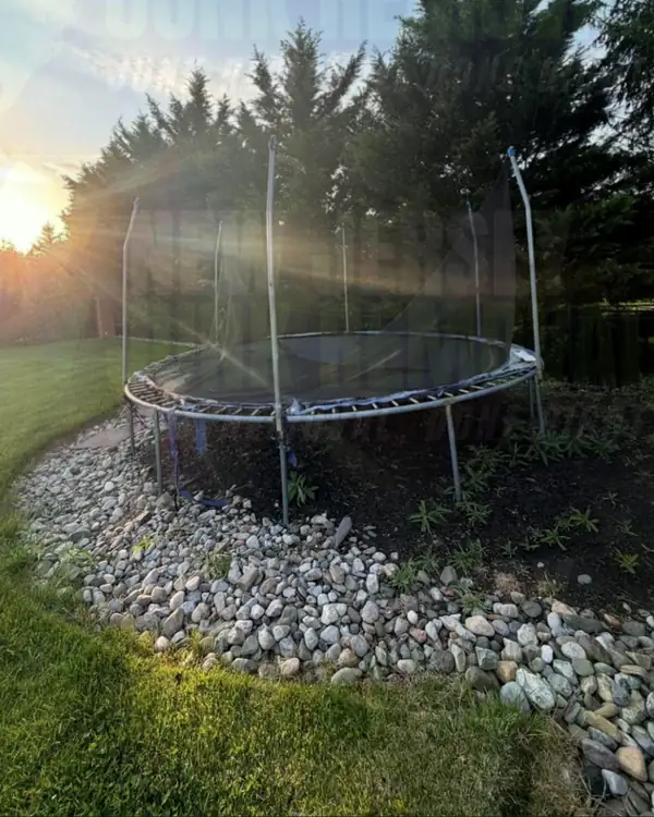 Before: an old trampoline in a stone-edged backyard bed