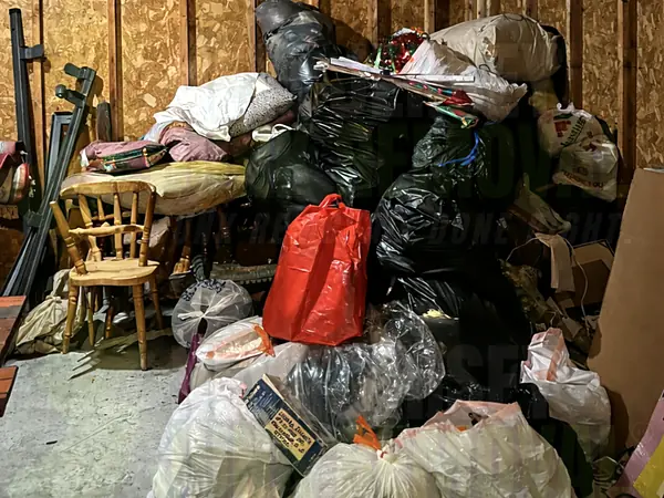 A room packed with bags, furniture and belongings before an estate cleanout