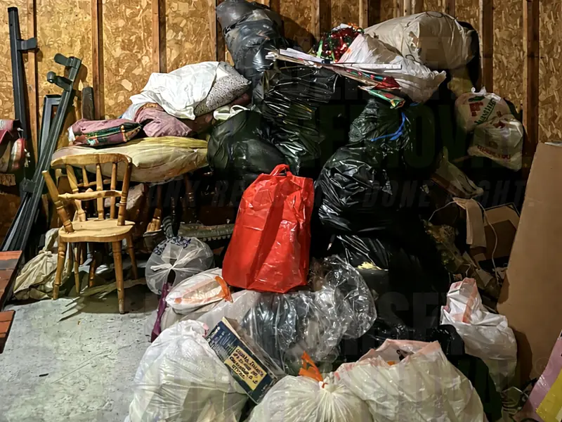 A room packed with bags, furniture and belongings before an estate cleanout